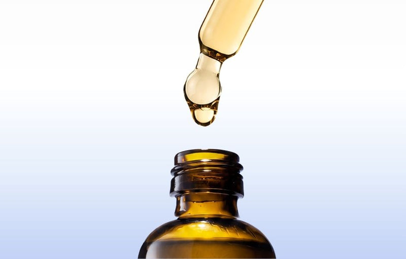 Pipette du sérum vitamine C Skin Diligent au-dessus de son flacon en verre ambré